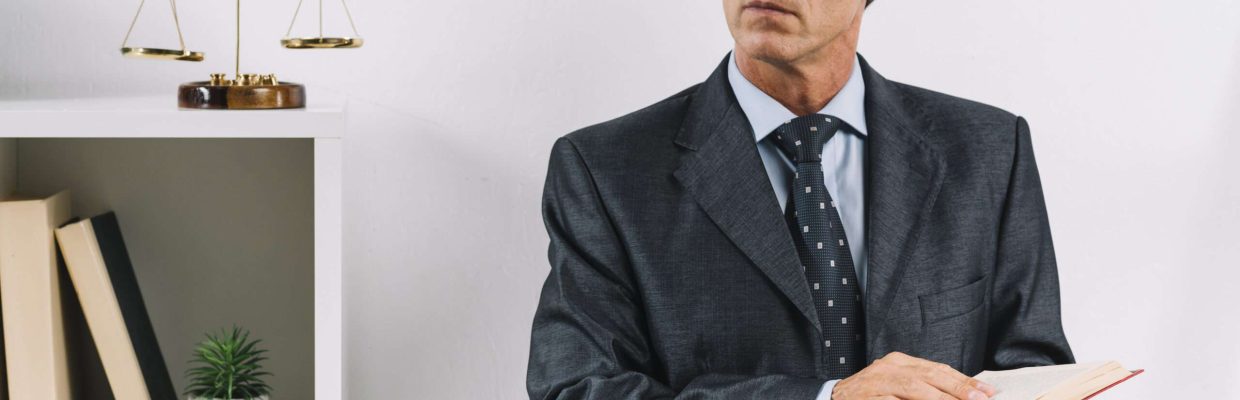mature-male-lawyer-holding-law-book-standing-courtroom